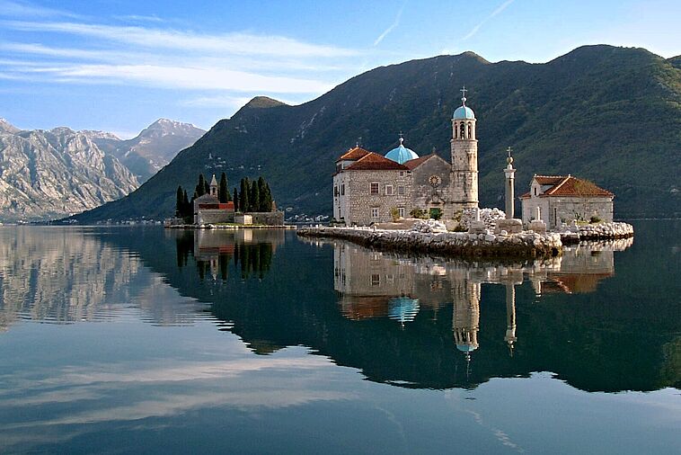 Blick über einen See auf die Stadt Perast