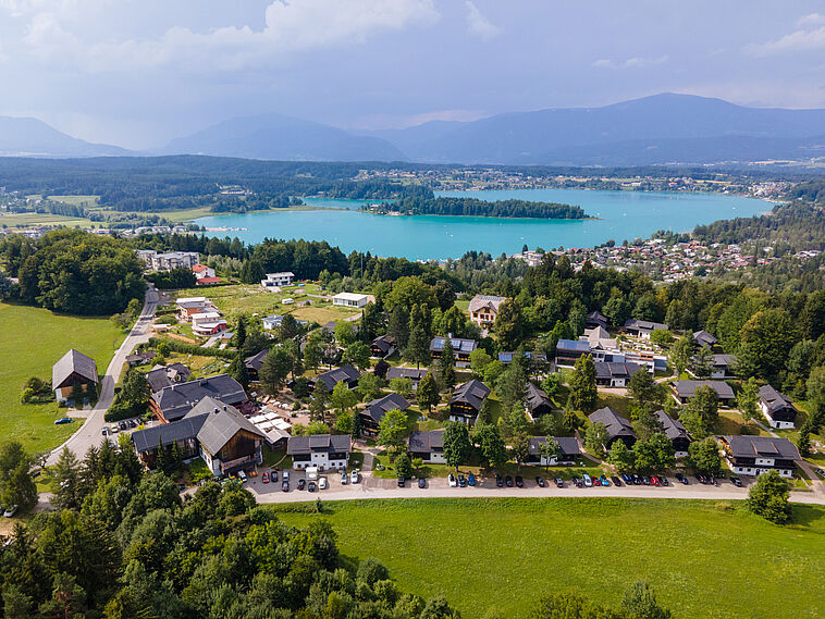 Blick über eine Kleinstadt mit See und Bergen im Hintergrund 