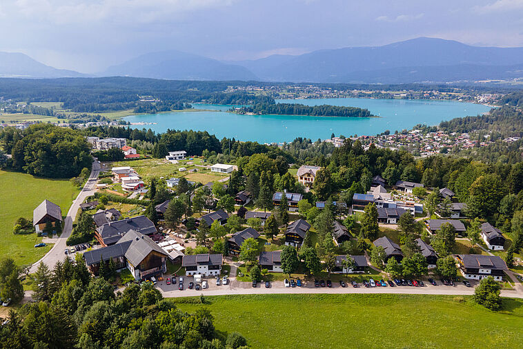 Blick über eine Kleinstadt mit See und Bergen im Hintergrund 