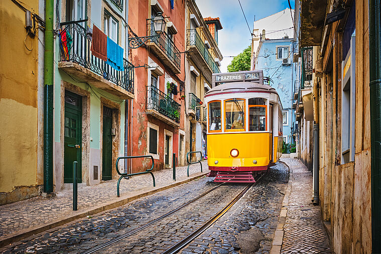 Gelbe Straßenbahn in kleiner Gasse in Lissabon