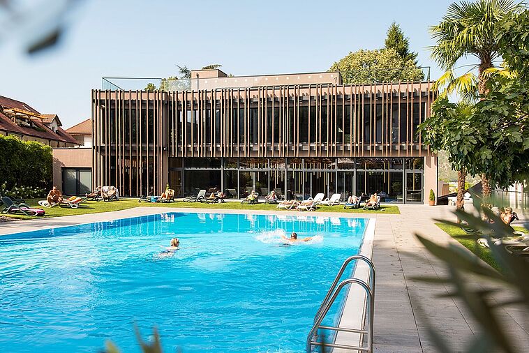 Blick über einen großen Pool auf die Fassade des Hotels