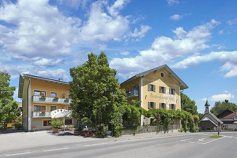 Blick auf ein Hotel von der Straße aus mit Baum davor